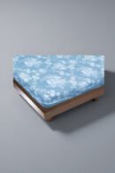 Funda ajustable de colchón 105x190 cm blanca sobre cama.